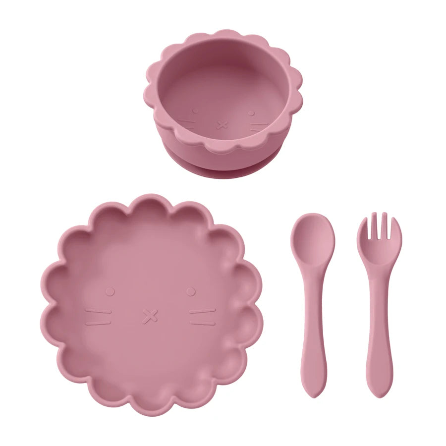 Pink children's dining set with bowl, plate, spoon, and fork on a white background