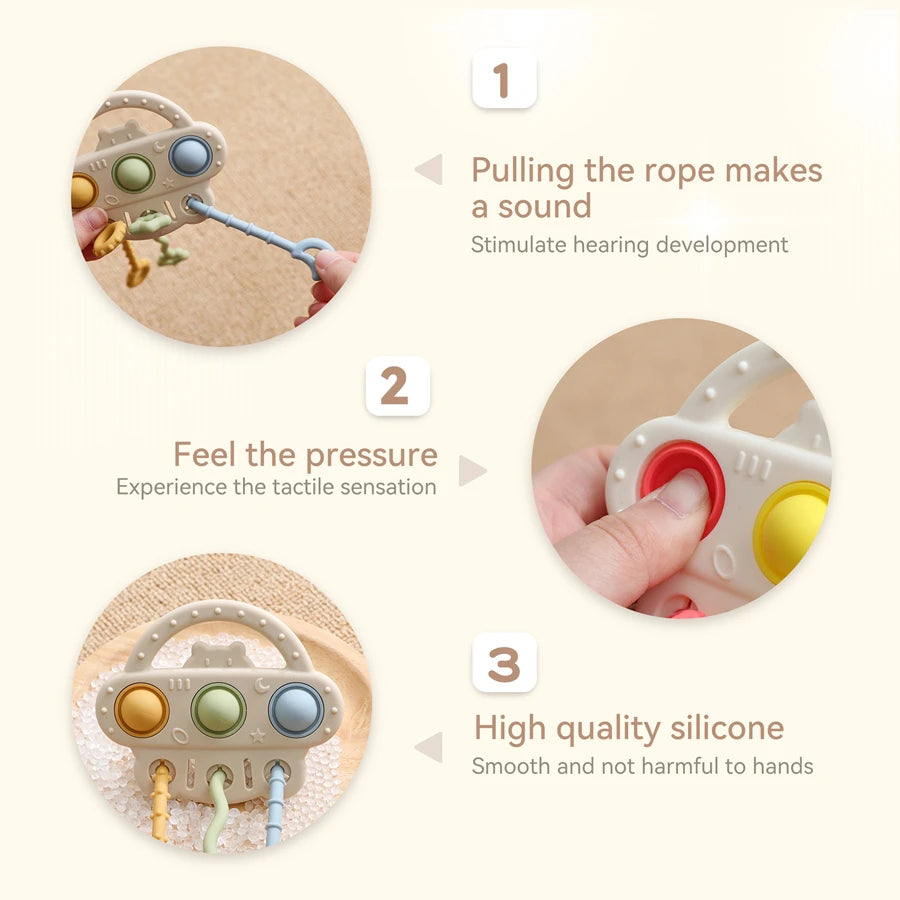 Three circular product feature callouts on a light cream background showing a baby sensory toy being held by a hand. Text reads: 1 Pulling the rope makes a sound / Stimulate hearing development, 2 Feel the pressure / Experience the tactile sensation, 3 High quality silicone / Smooth and not harmful to hands.