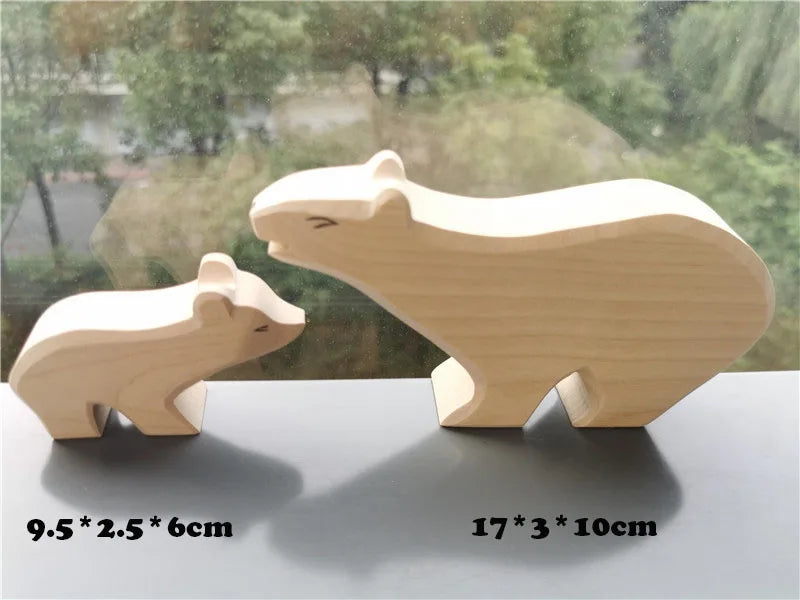 Two wooden bear figurines on a reflective surface with a blurred outdoor background