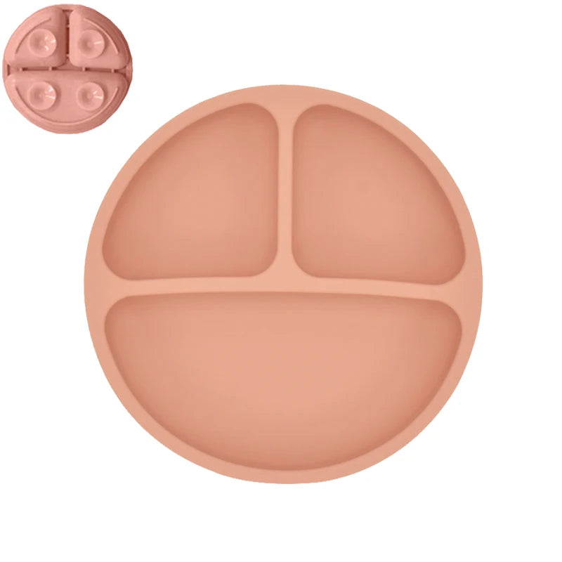 Pink silicone plate with divided sections on a white background