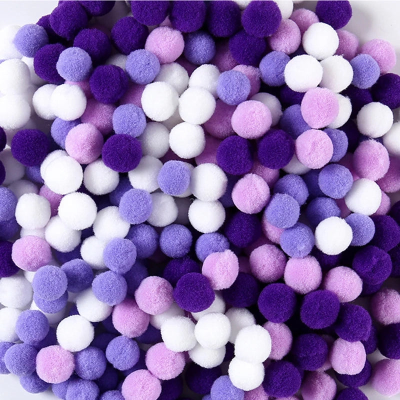 Assorted purple, pink, and white pom-poms on a white background