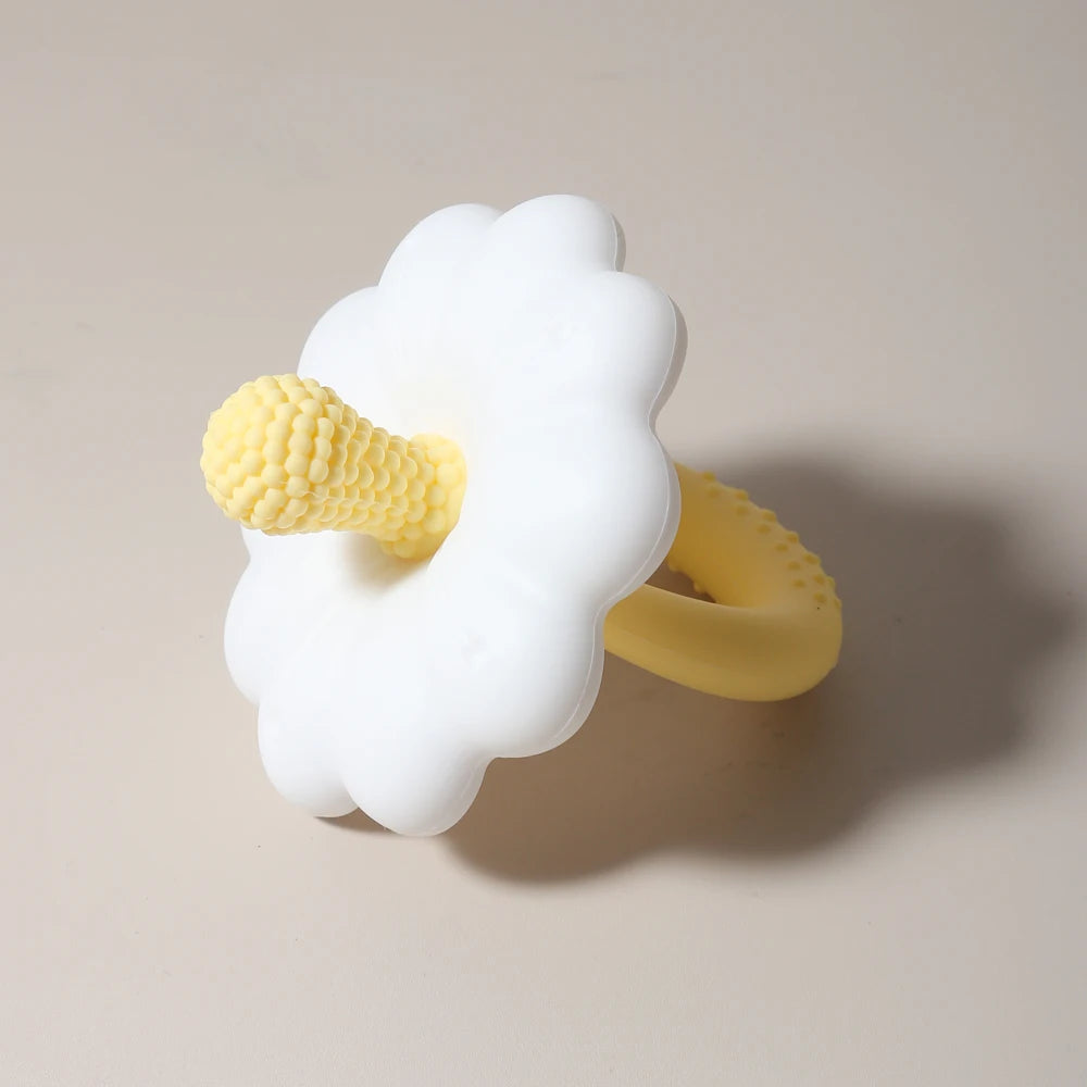 White cloud-shaped teething ring with yellow accents on a beige background