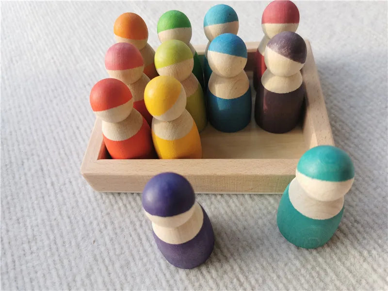 Colorful wooden peg dolls in a wooden box on a textured surface