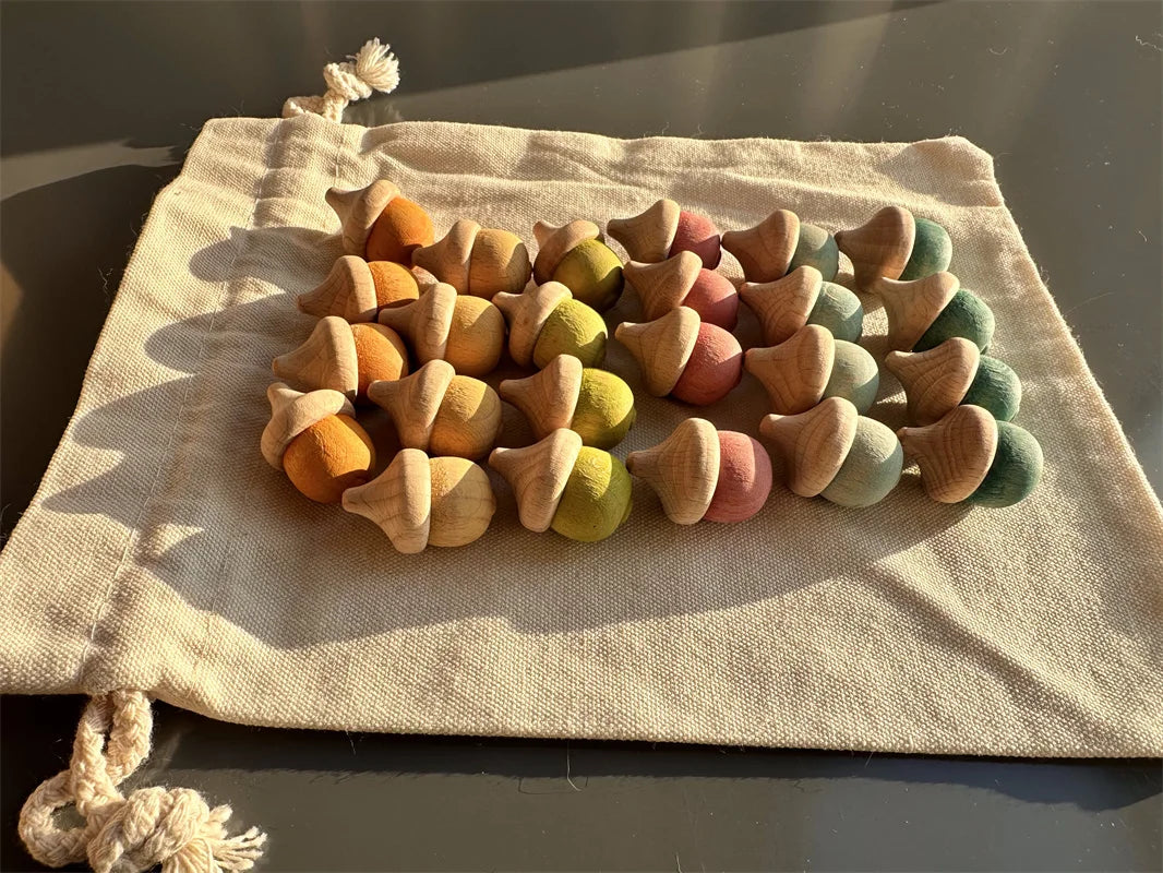 Colorful wooden acorn-shaped toys on a beige drawstring bag.