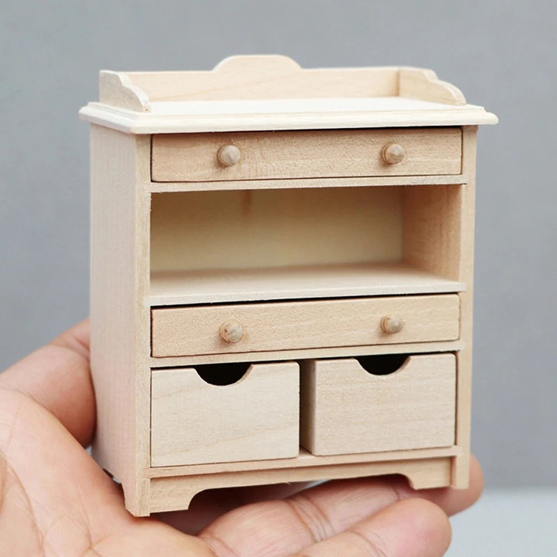 Small wooden dresser with drawers held in a hand against a gray background