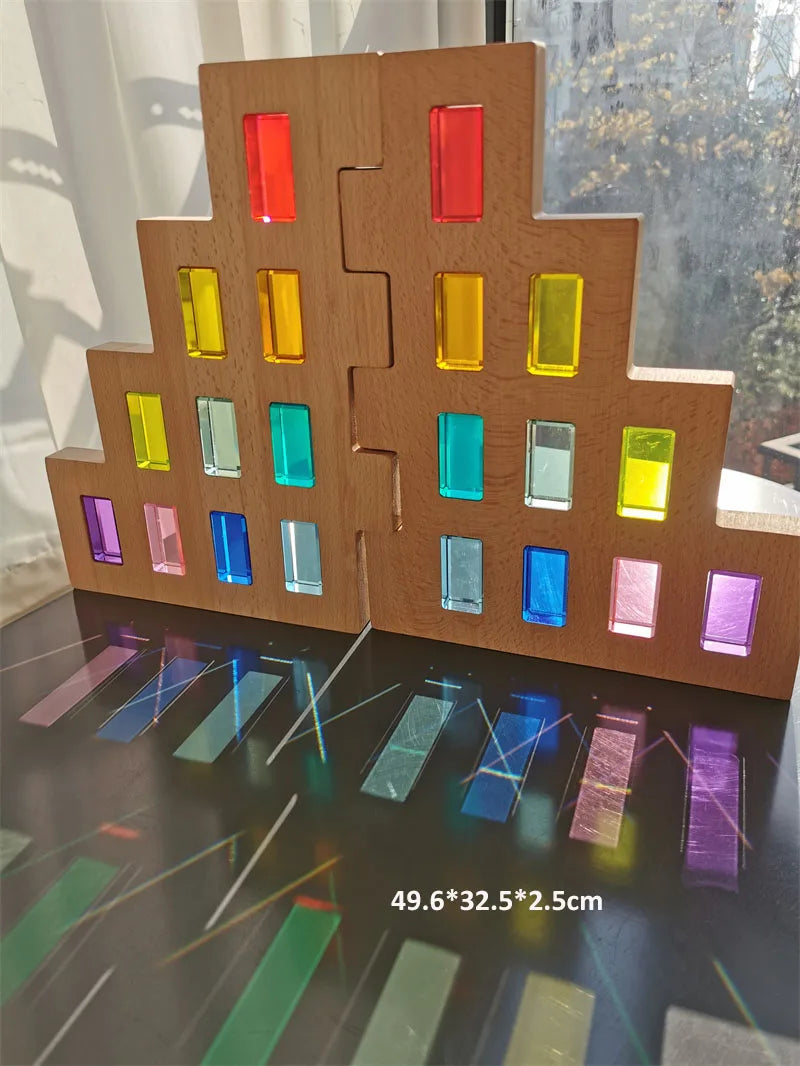 Wooden building model with colorful glass panels on a reflective surface.