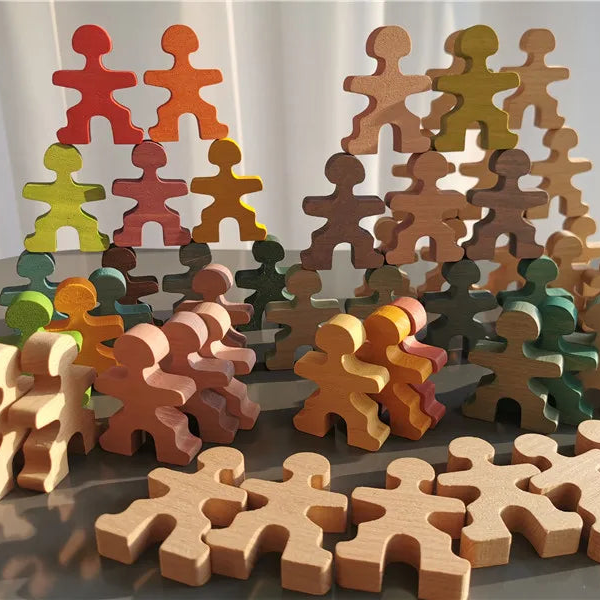 A set of wooden puzzle-piece shaped toy figures in various natural wood tones and painted colors, arranged on a reflective surface with a soft white curtain background.