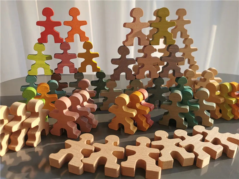 Colorful wooden puzzle pieces shaped like people on a reflective surface.