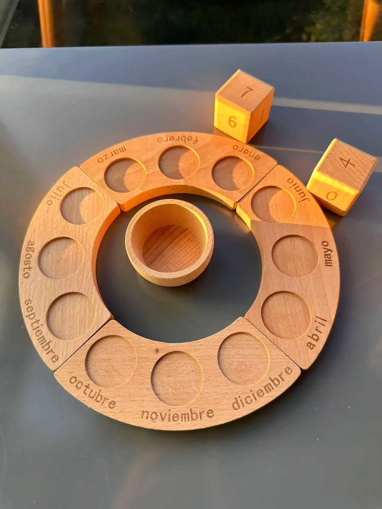 Wooden calendar wheel with wooden blocks on a reflective surface