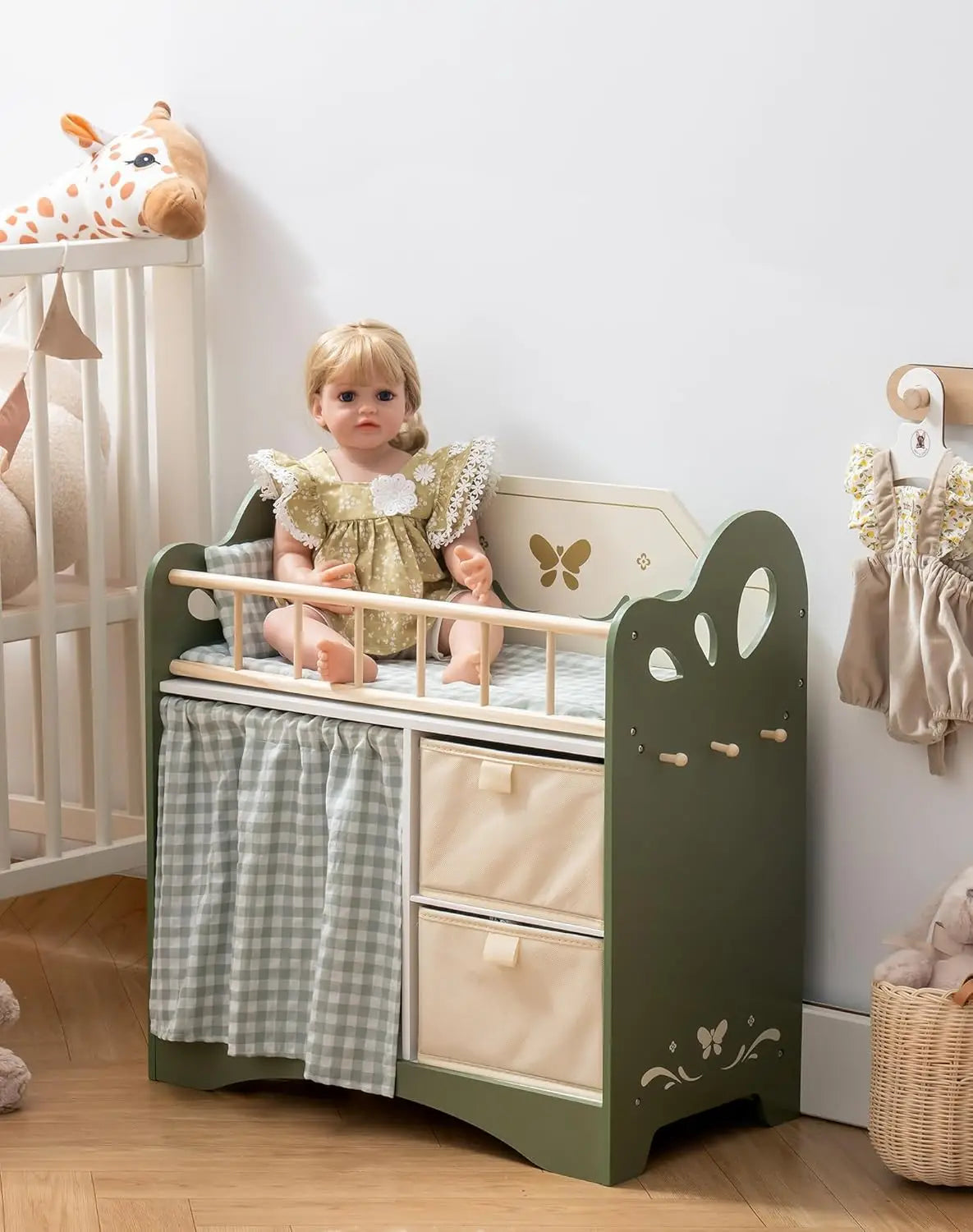 Child's play area with a green and beige changing table, doll, and toys.