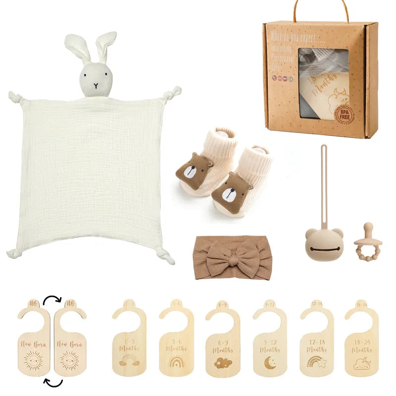 Collection of baby items including a blanket, booties, headband, and decorative items on a white background.