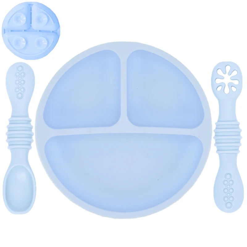 Blue silicone dinner set with plate, spoon, and fork on a white background