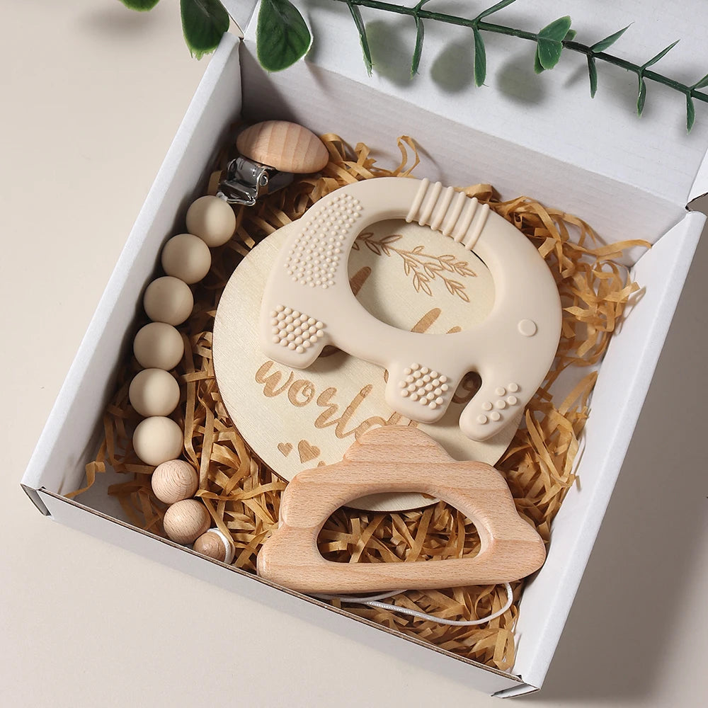 Set of wooden baby teething toys in a gift box with decorative elements.