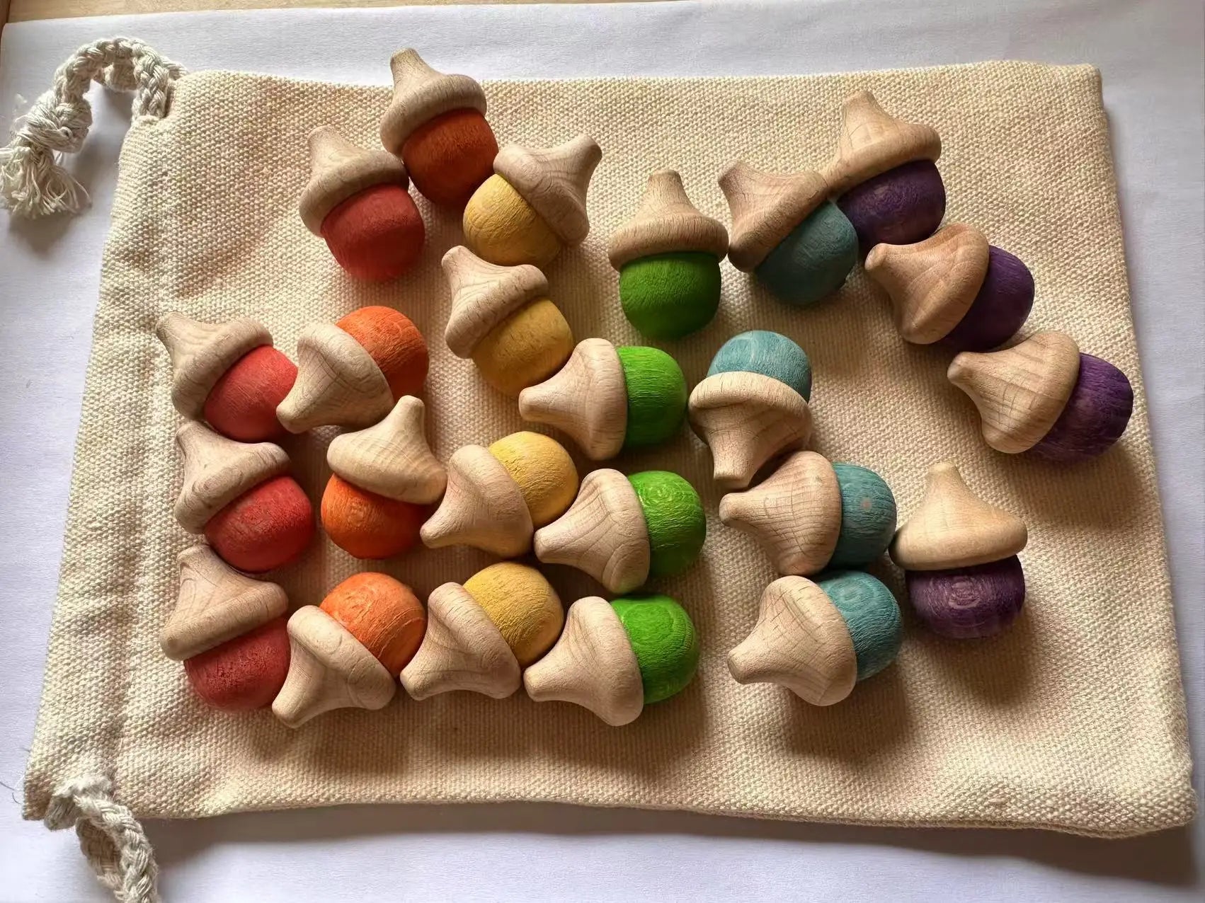 Colorful acorn-shaped toys on a beige fabric bag