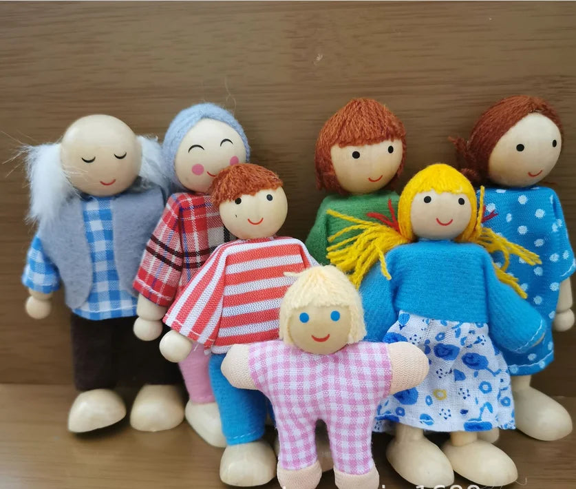Set of wooden dolls with colorful clothing on a wooden background