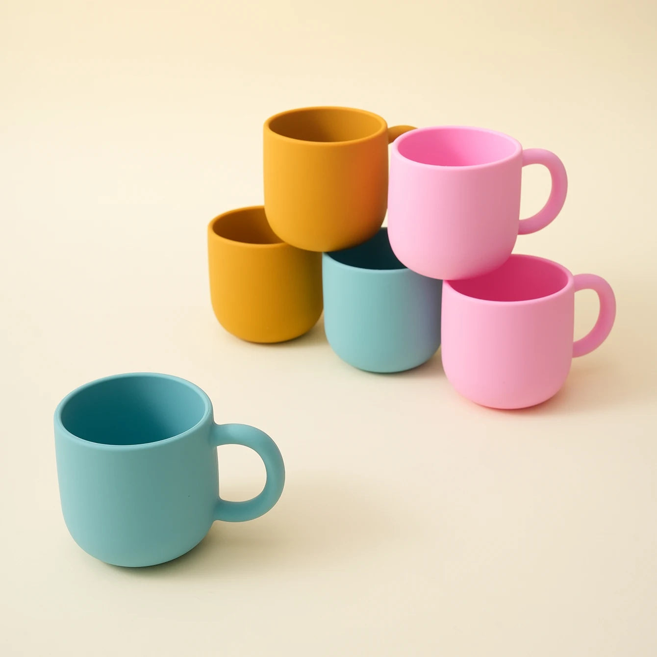 Stacked silicone toddler mugs in three colors