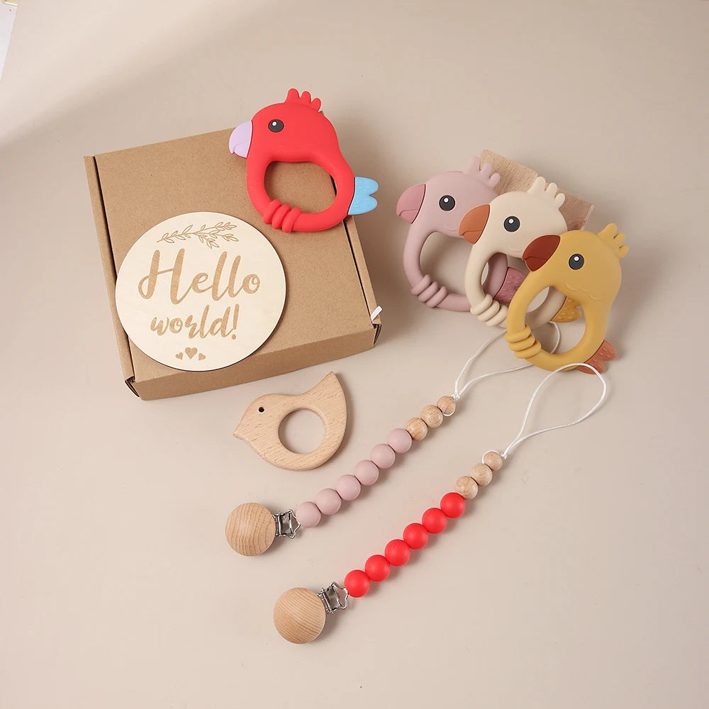 Set of baby teething toys with a 'Hello world!' sign on a beige background