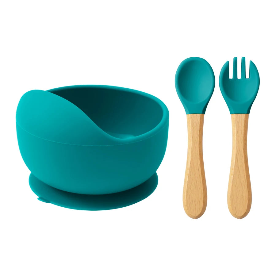 Teal silicone suction bowl with wooden spoon and fork