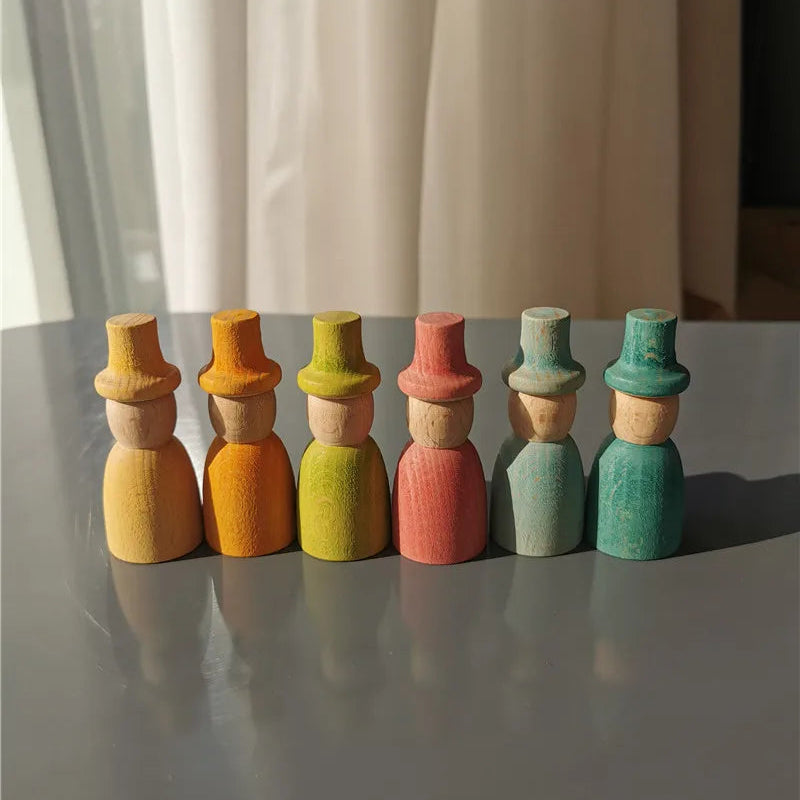 Set of colorful wooden peg dolls on a reflective surface with a neutral background