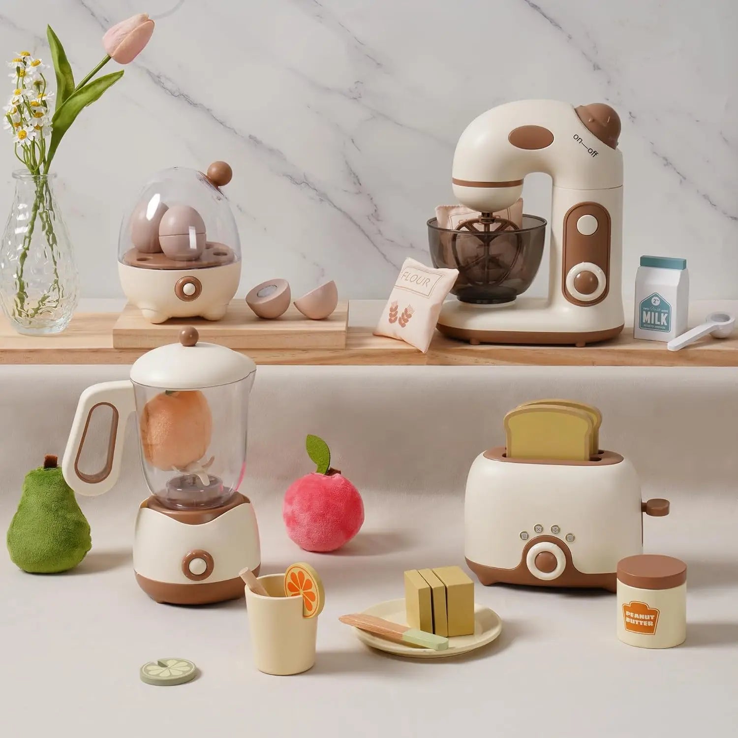 Set of toy kitchen appliances including a mixer, toaster, and coffee maker on a light surface with a marble wall background.