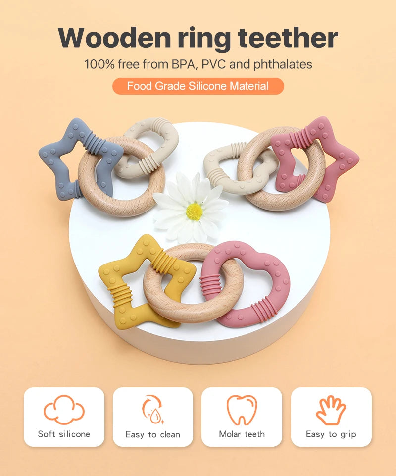Wooden ring teether set with silicone ends on a white plate against an orange background
