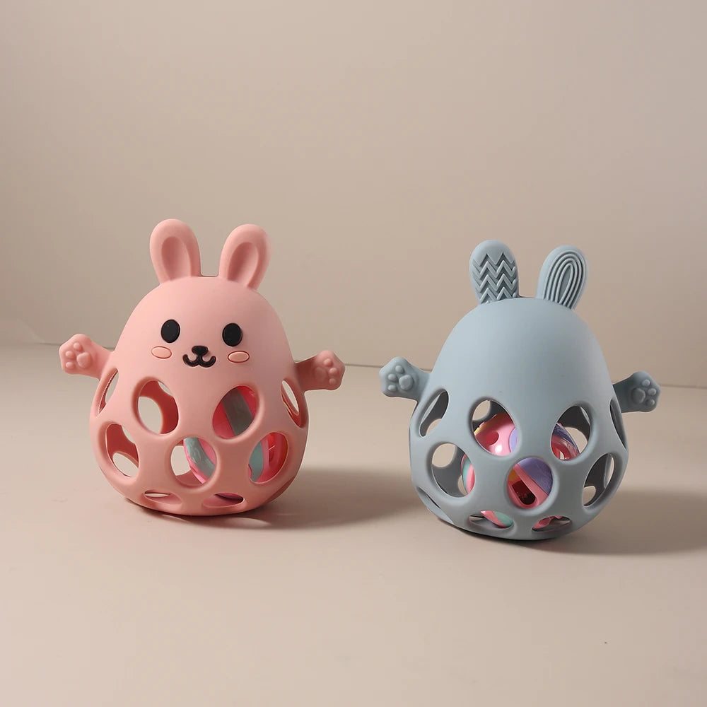 Two pink and blue rabbit-shaped toys on a beige background