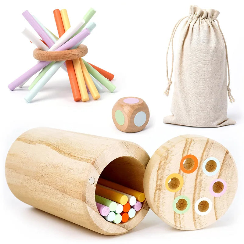 Set of wooden toys including colorful sticks, a dice, and a wooden container with more sticks inside on a white background.
