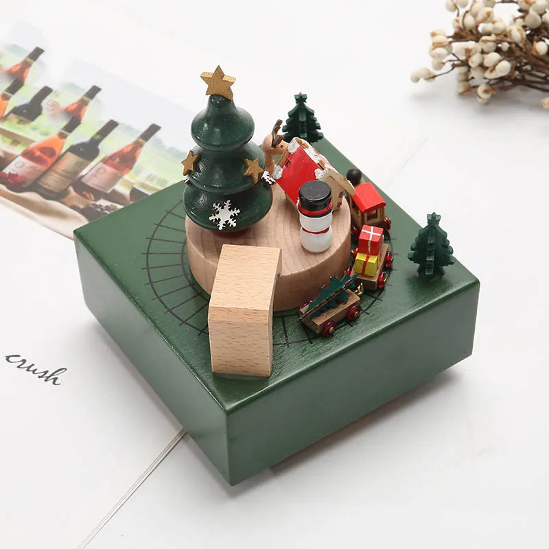 Decorative Christmas scene with a toy train, trees, and figures on a green base.