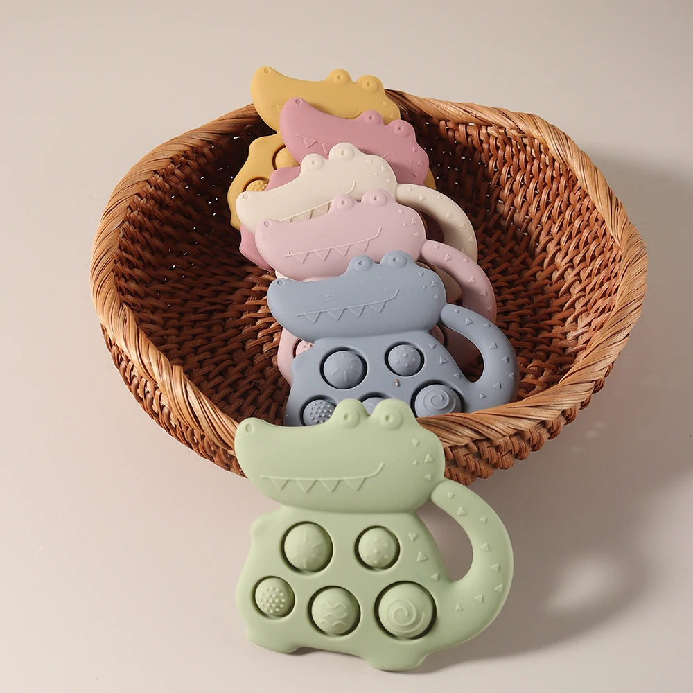 Colorful silicone teething toys in a wicker basket on a beige background