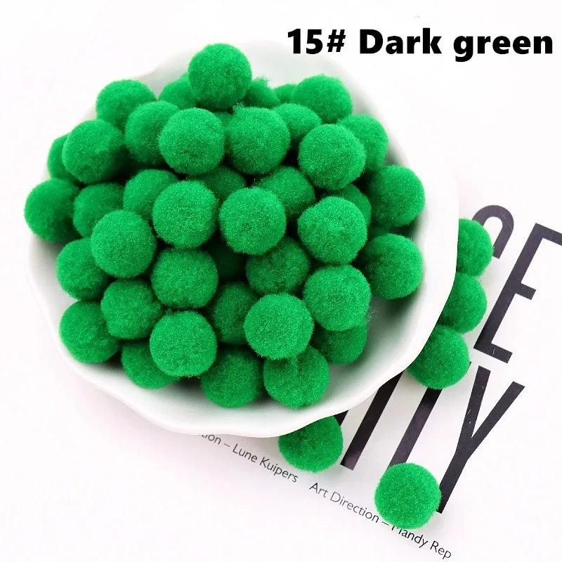 White bowl filled with dark green pom-poms on a white background