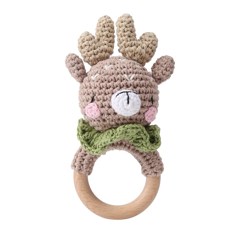 Crocheted deer rattle with wooden ring on a white background