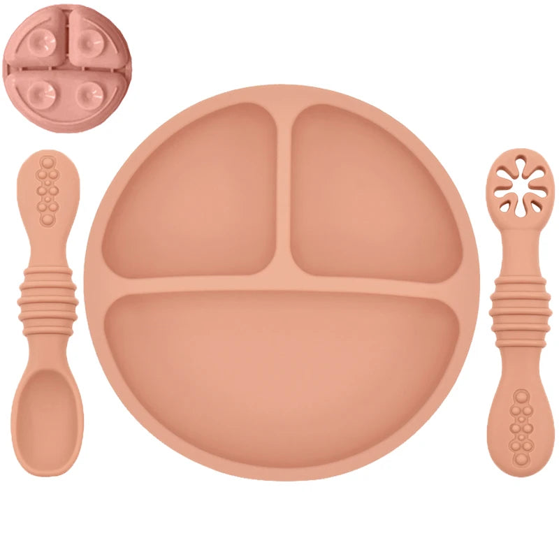 Set of silicone dining utensils including a plate, spoon, and fork on a white background