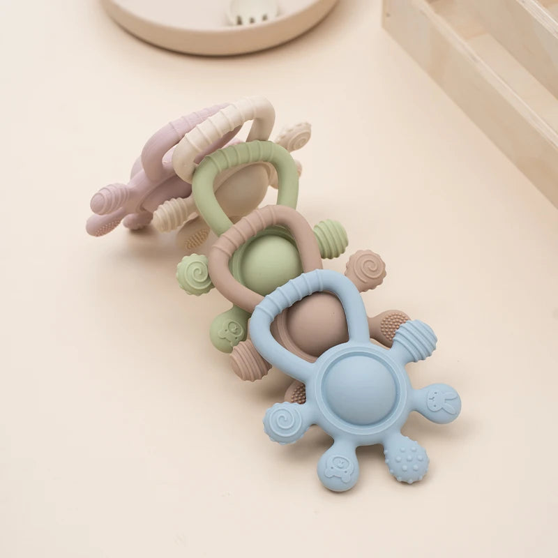 Set of colorful baby teething rings on a light surface