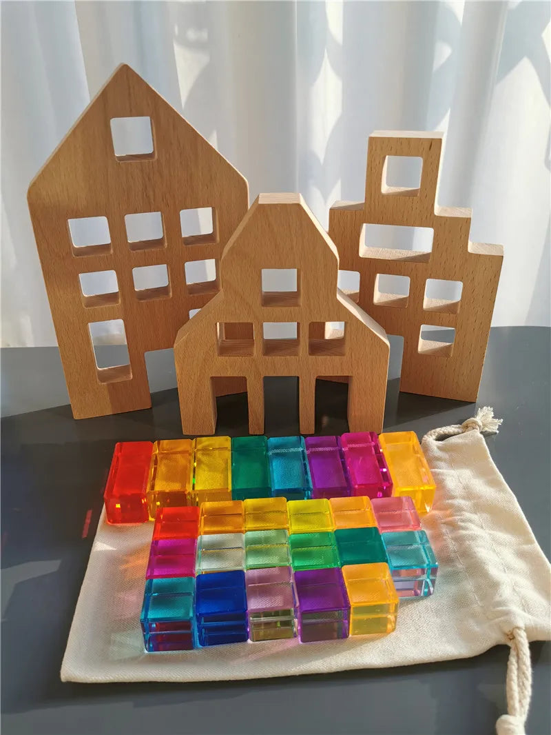 Colorful transparent blocks with wooden house models on a gray surface.