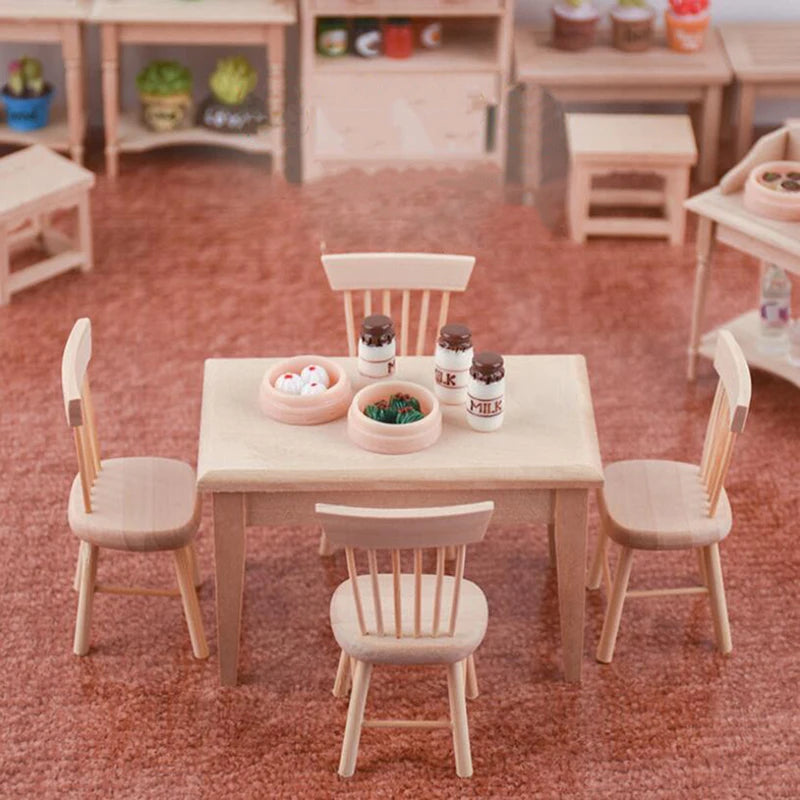 Miniature table and chairs set on a red carpet with small items on the table.
