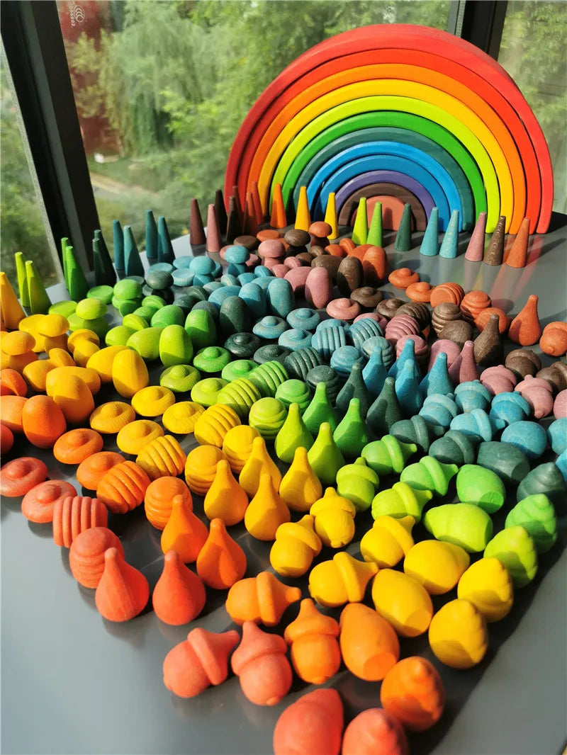 Colorful rainbow-themed playset with wooden rainbow and various colored blocks on a reflective surface.