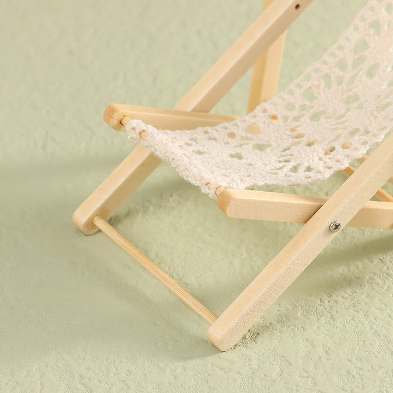Wooden folding chair with a white woven seat on a light green background. Oliver & Company Montessori Toys