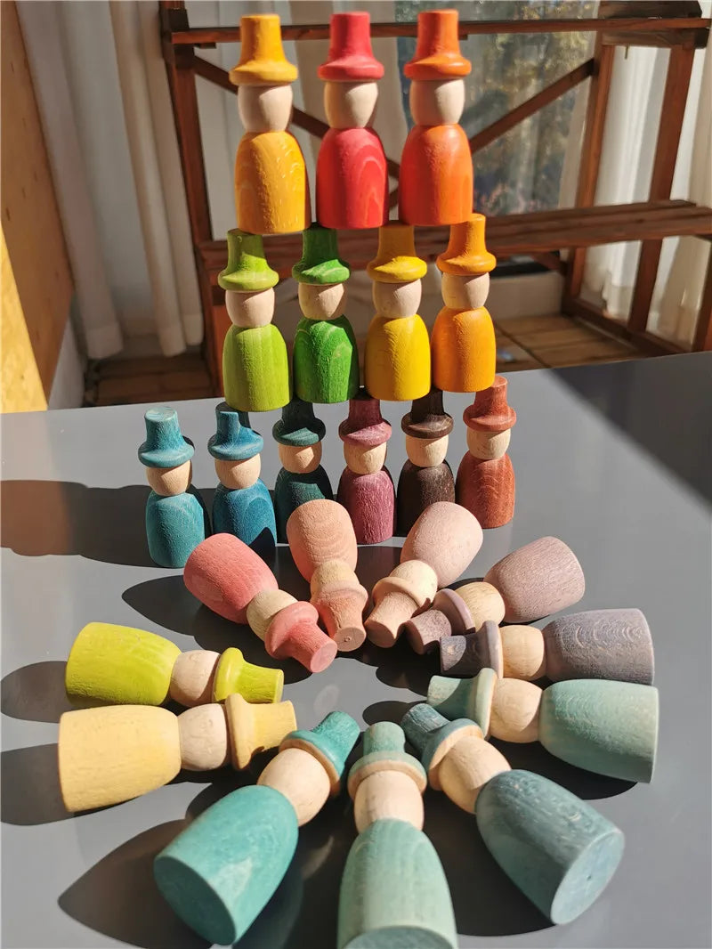 Colorful wooden peg dolls stacked on a reflective surface with a blurred background