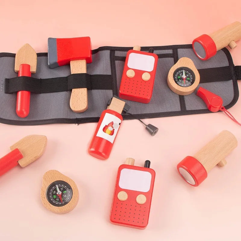 Set of wooden toy tools and communication devices on a pink background