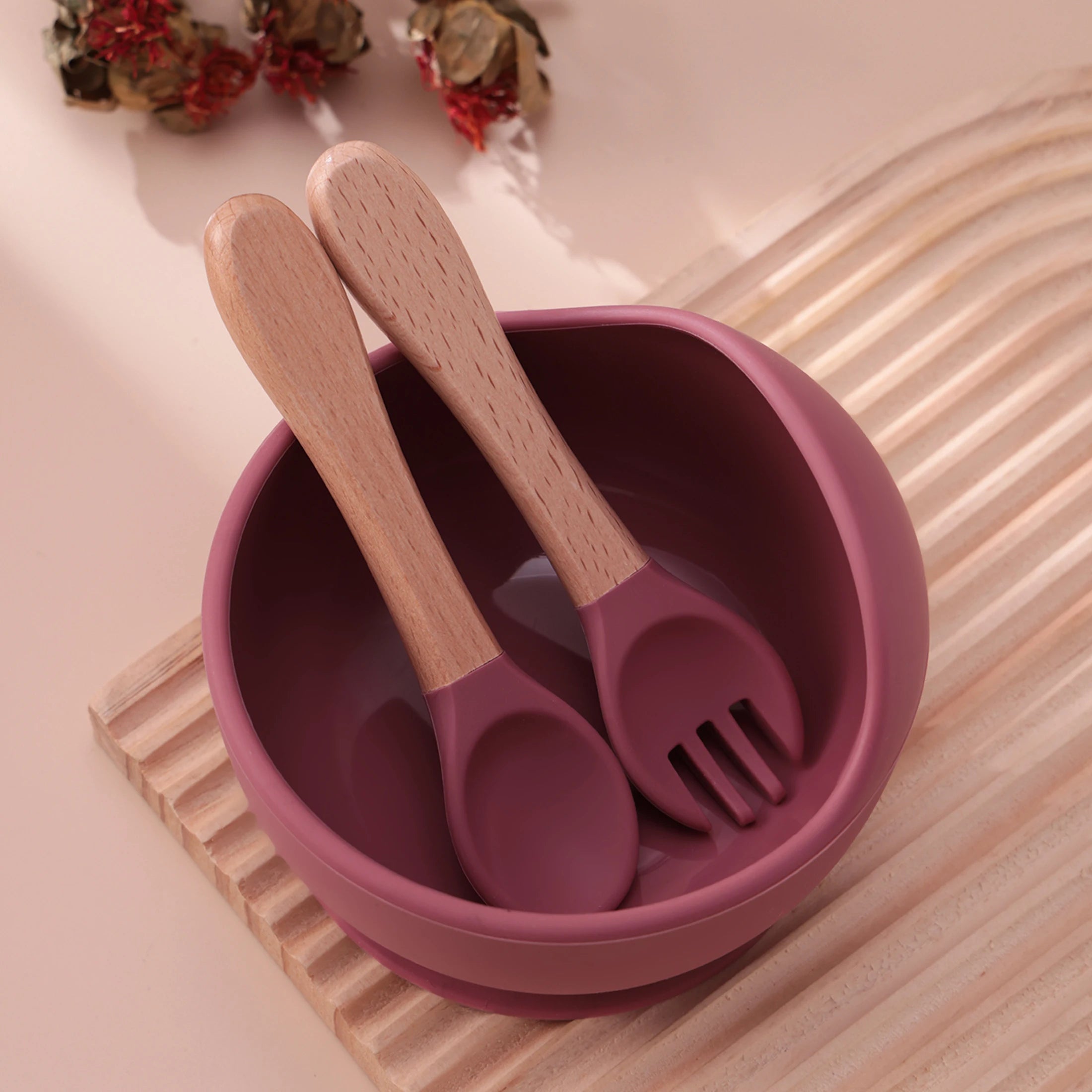 Plum suction bowl with wooden spoon and fork inside