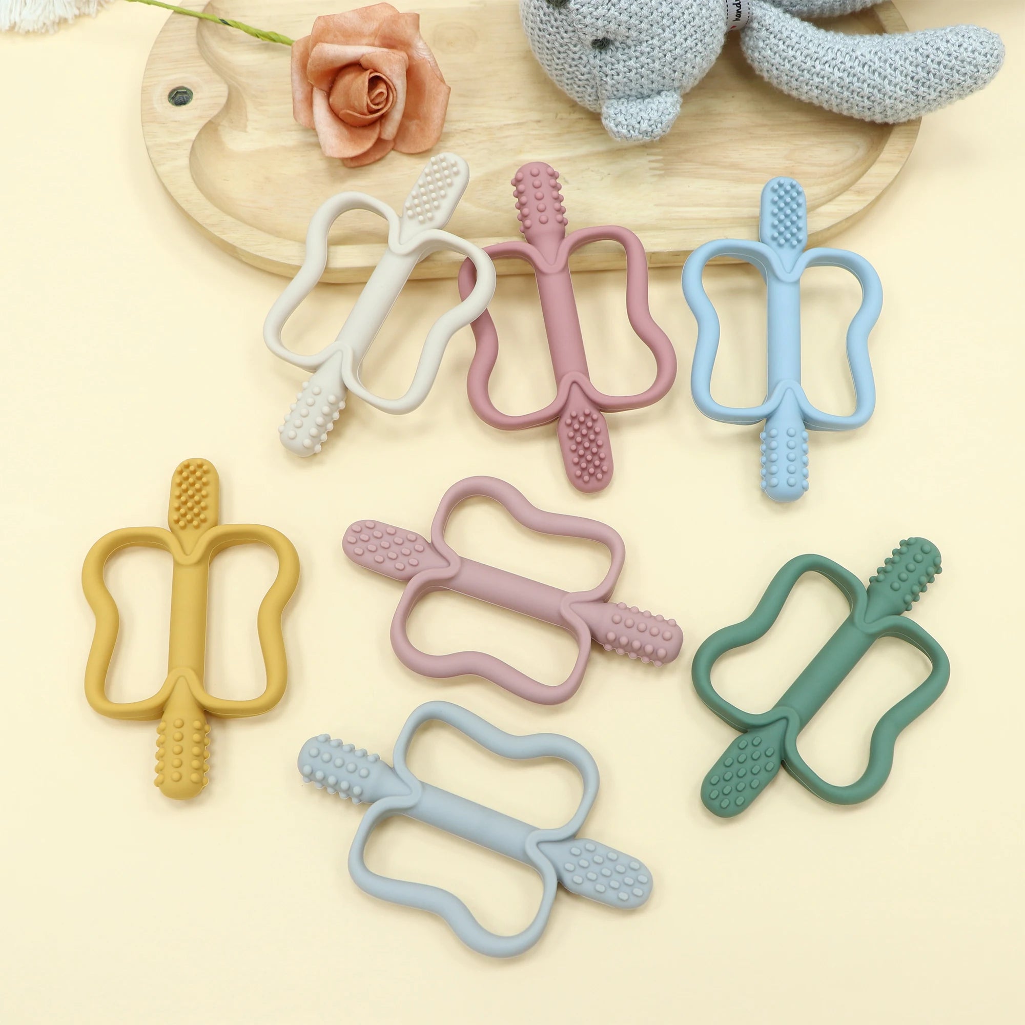 Set of colorful silicone baby teething toys on a light background