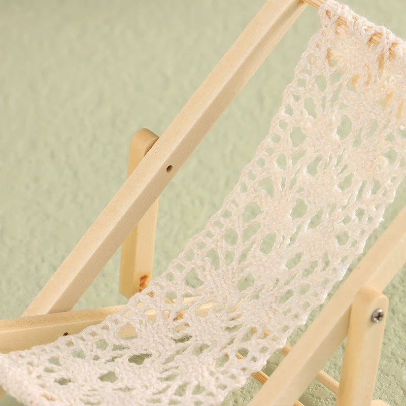 Crocheted white blanket draped over a wooden ladder against a light green wall.Oliver & Company Montessori Toys