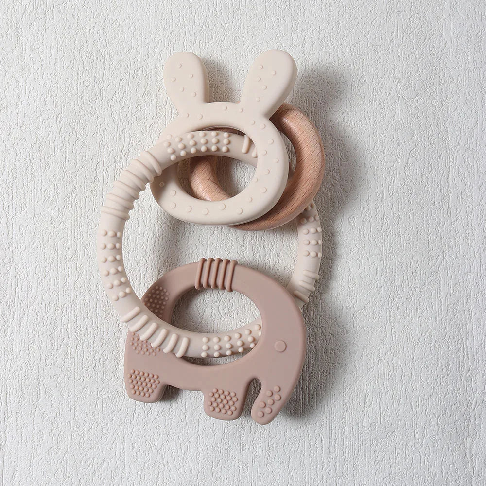 Pink and beige teething ring with bunny design on a light gray background