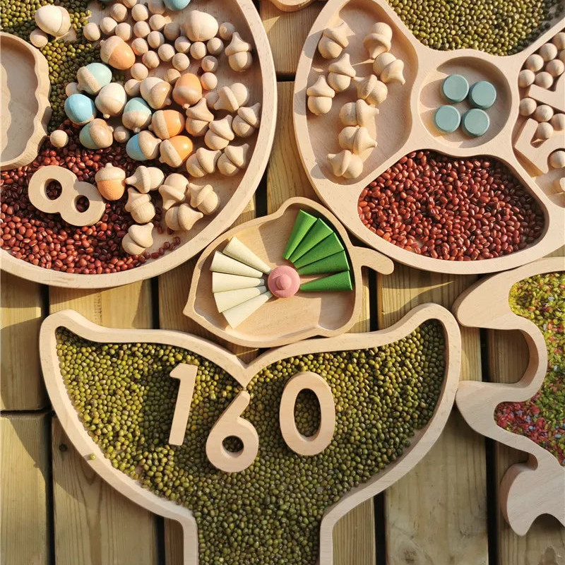 A set of natural wood fraction-shaped measuring trays filled with green beans, red beans, and small wooden beads, arranged on a wooden surface.