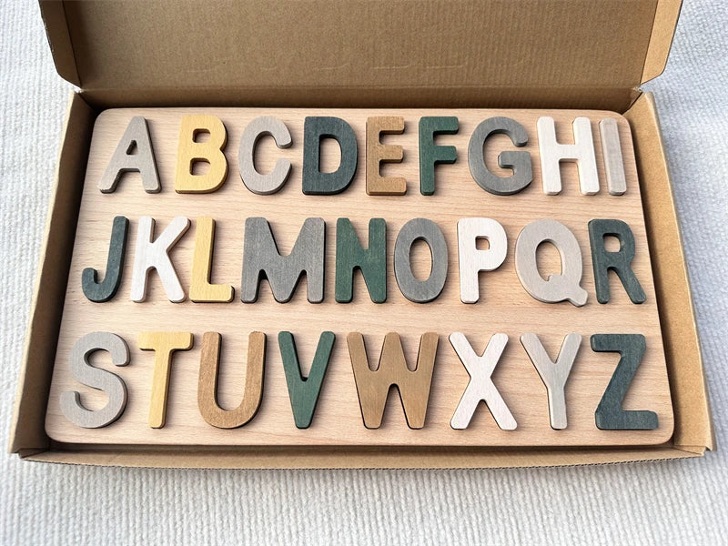 Wooden alphabet letters set in a box on a light background