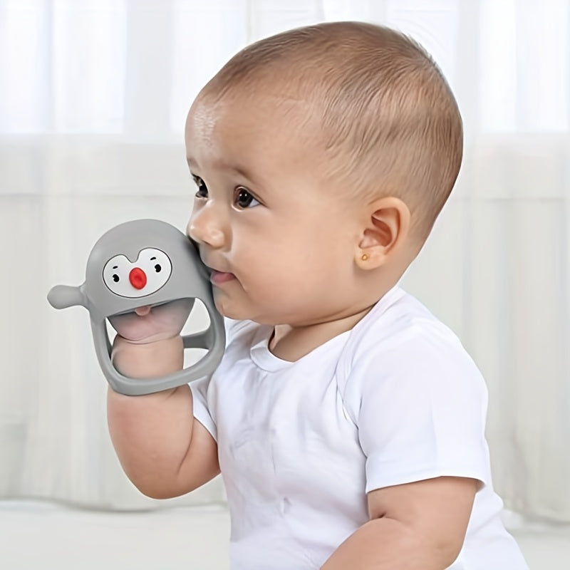 Baby holding a gray teething toy with a cartoon face against a white background