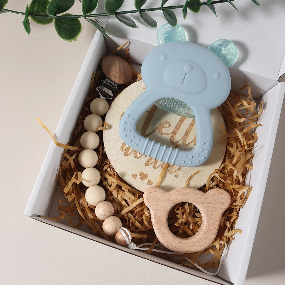 Baby teething toy set with wooden and silicone elements in a decorative box.