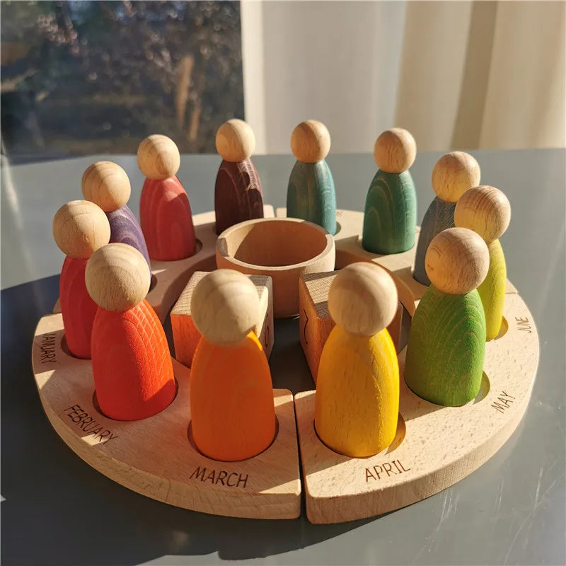 Wooden peg dolls arranged in a circle on a wooden board with months labeled.