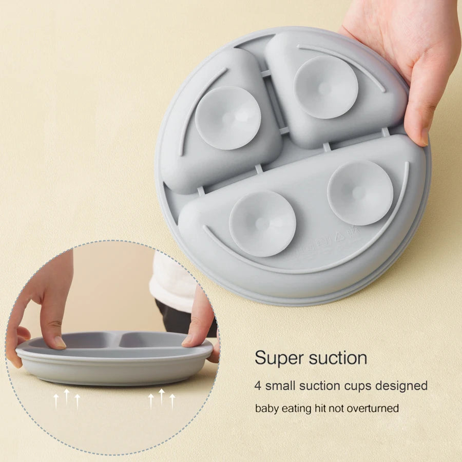 A gray silicone baby feeding plate with suction cups, shown being held by a hand on a beige background, with a circular inset demonstrating the suction cup and text reading 'Super suction'.