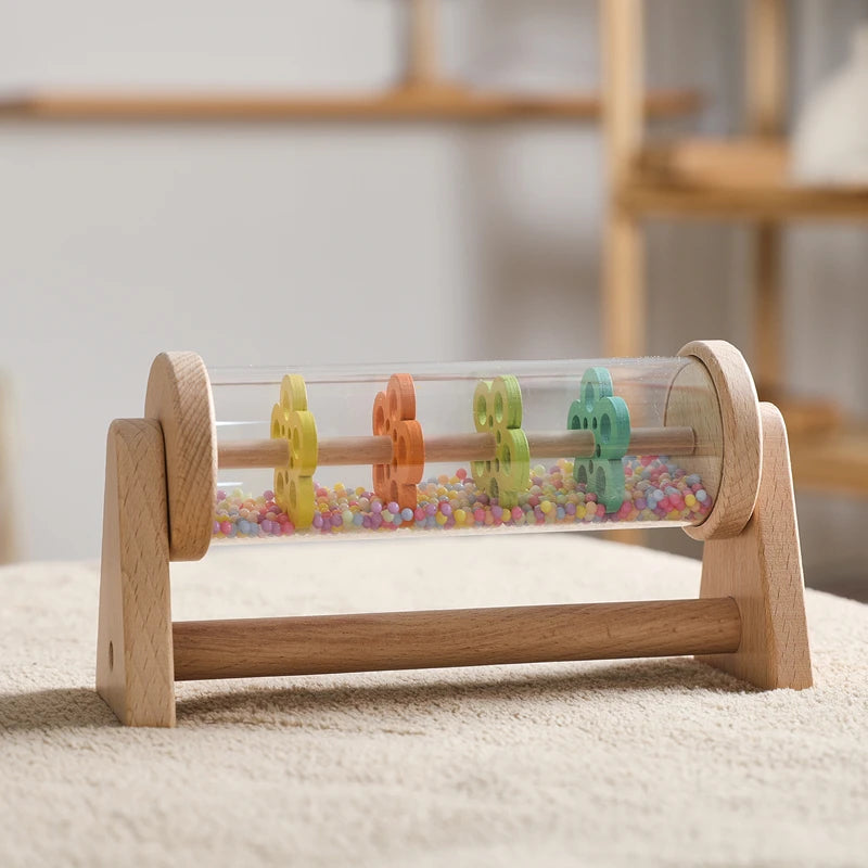 Wooden toy with colorful beads and transparent cylindrical section on a neutral background